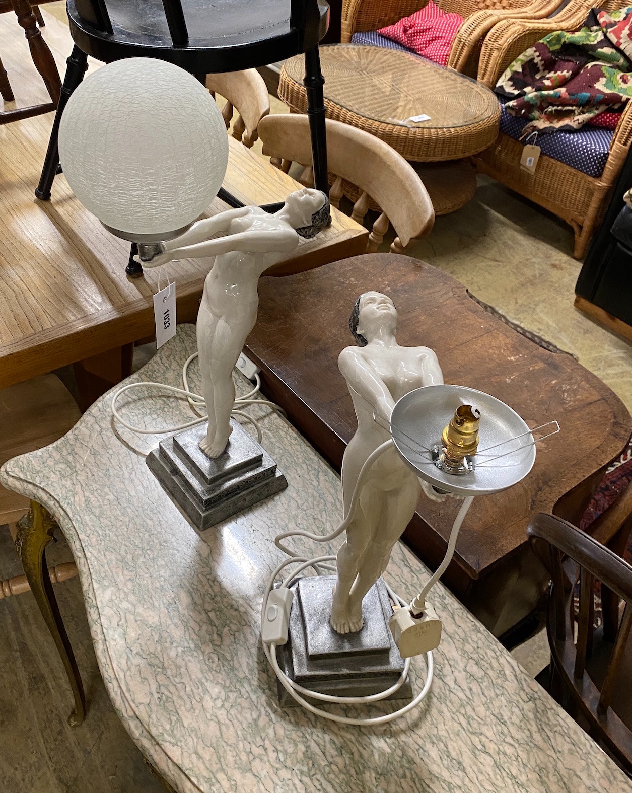 A pair of Art Deco style resin figural lights (lacking one globe), height 55cm